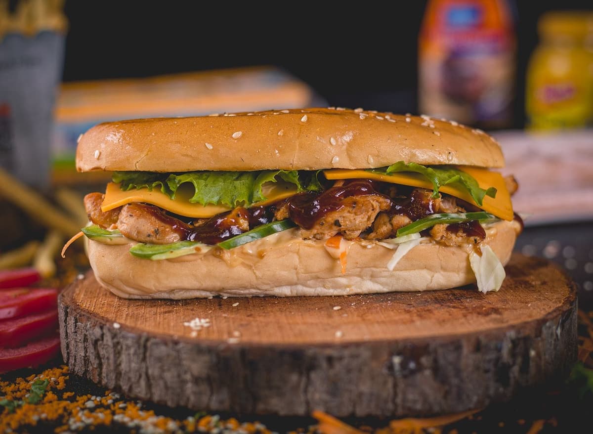 Sub sandwich with cheese, lettuce, juicy beef  etc. 