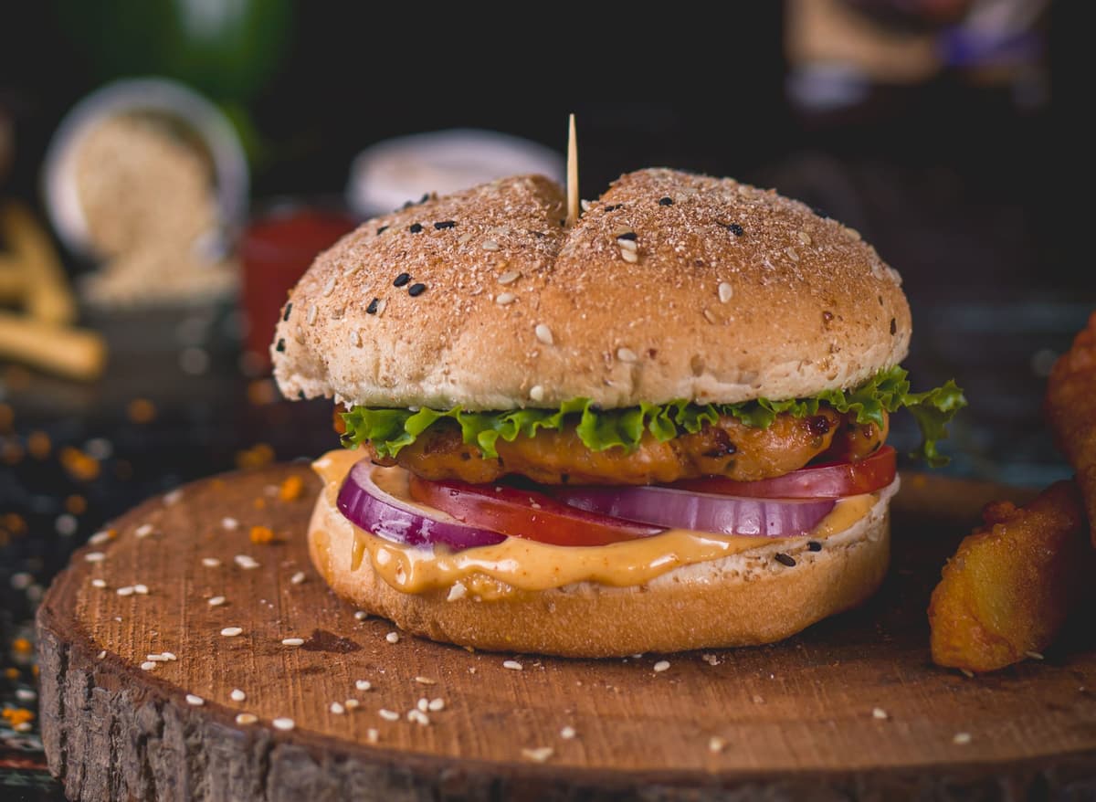 Burger with juicy chicken patty, onions, cheese, tomato.