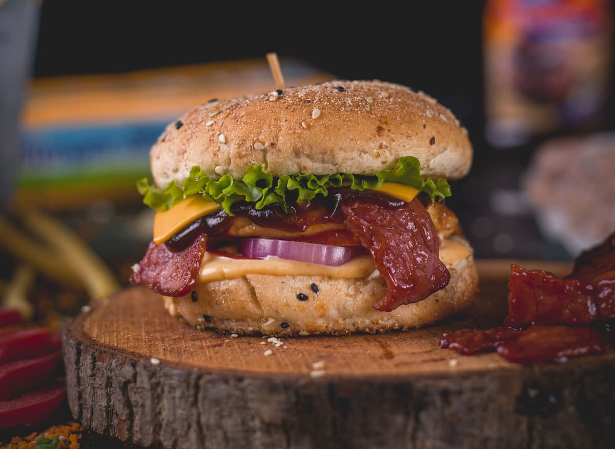 Burger loaded with bacon, then served with cheese fresh onions, lettuce.